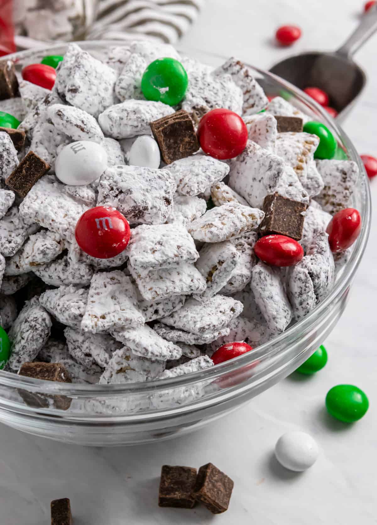 Christmas mint Puppy Chow in bowl with red and green M&Ms.