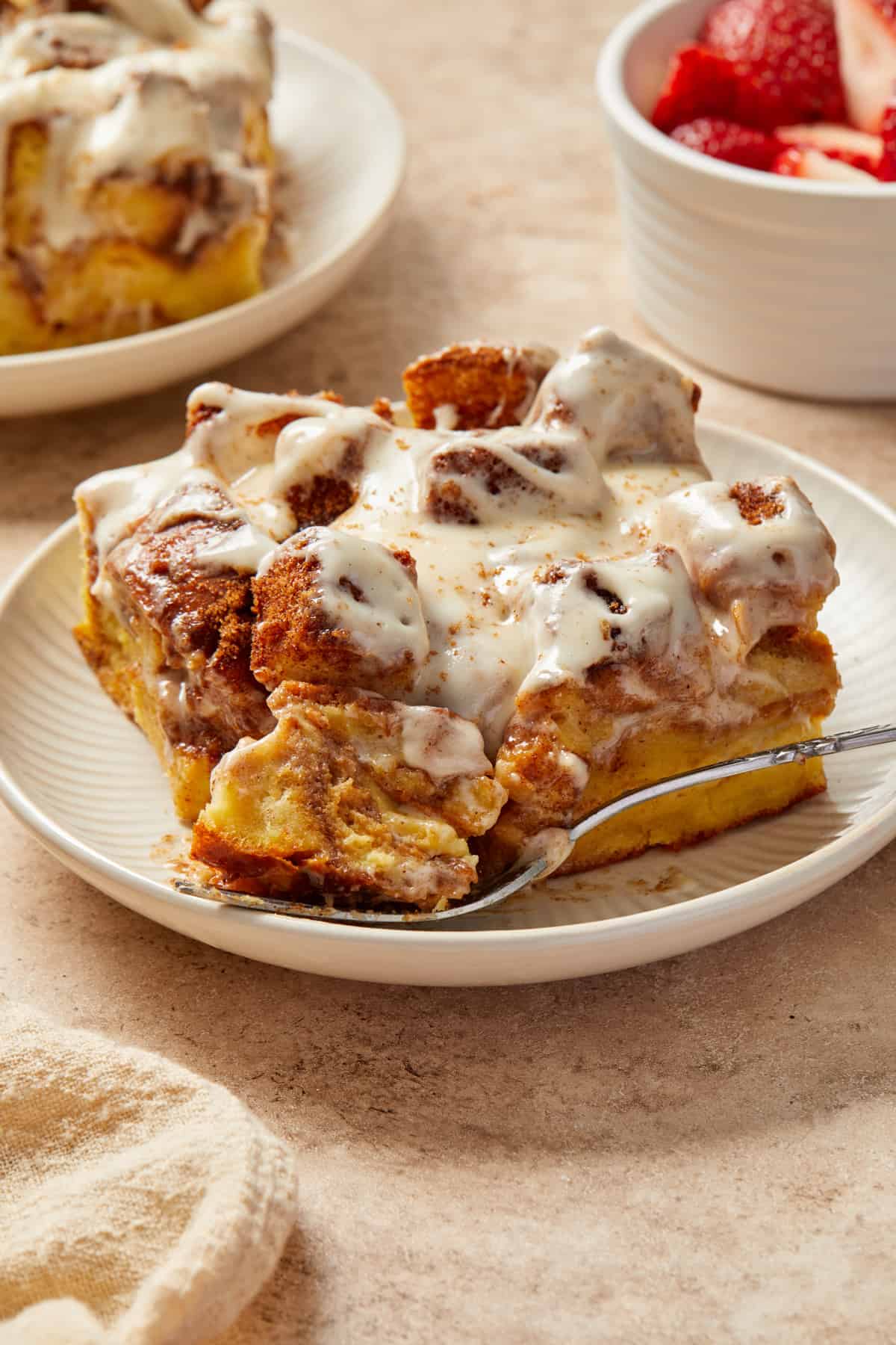 Cinnamon French toast casserole made with Brioche bread sliced on plate with forkful.