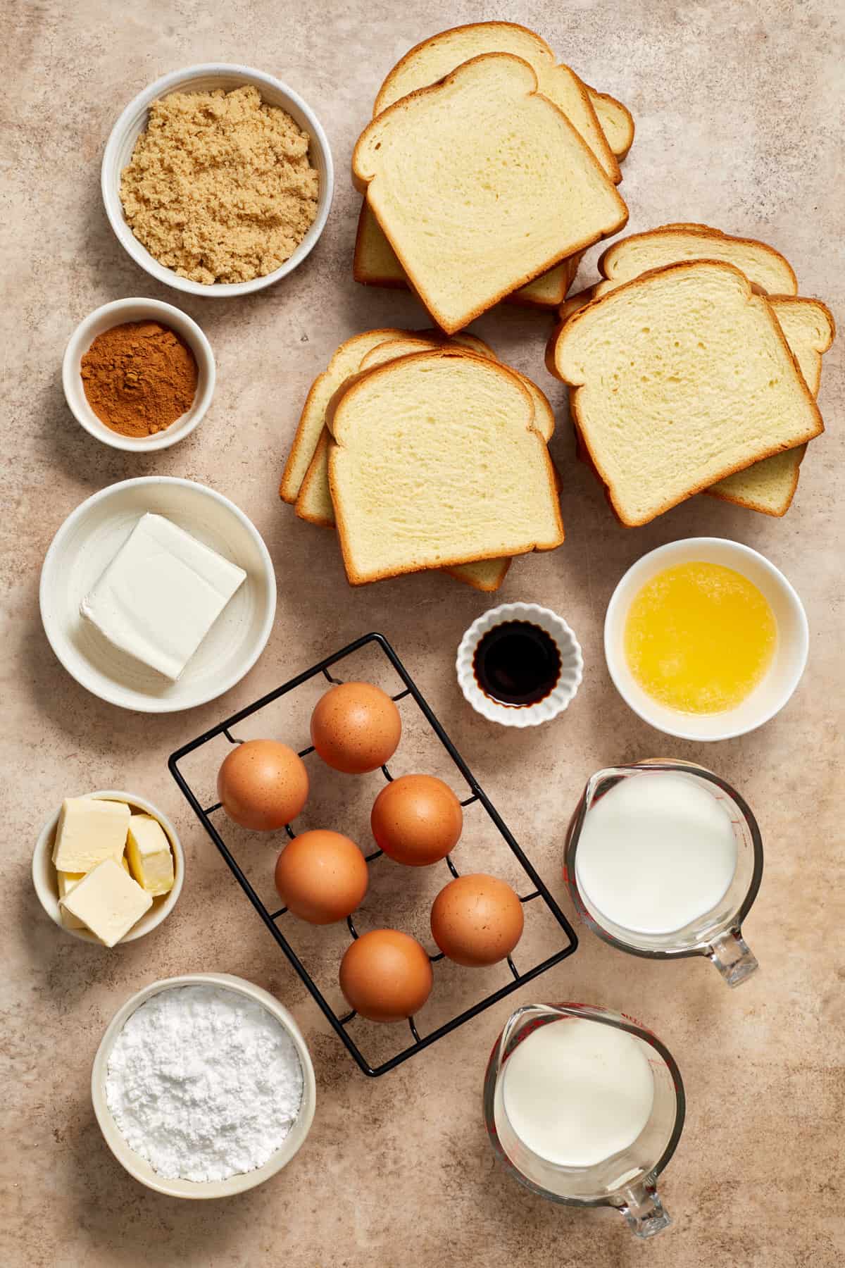 Eggs, milk, cream, butter, Brioche bread and other ingredients arranged on surface.