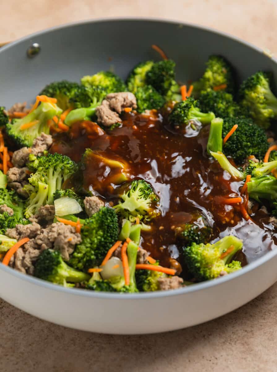 Teriyaki sauce added to skillet with stir fried meat and veggies.