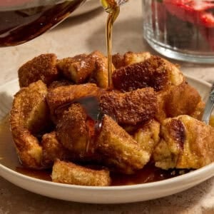 Maple syrup being poured over French toast casserole.