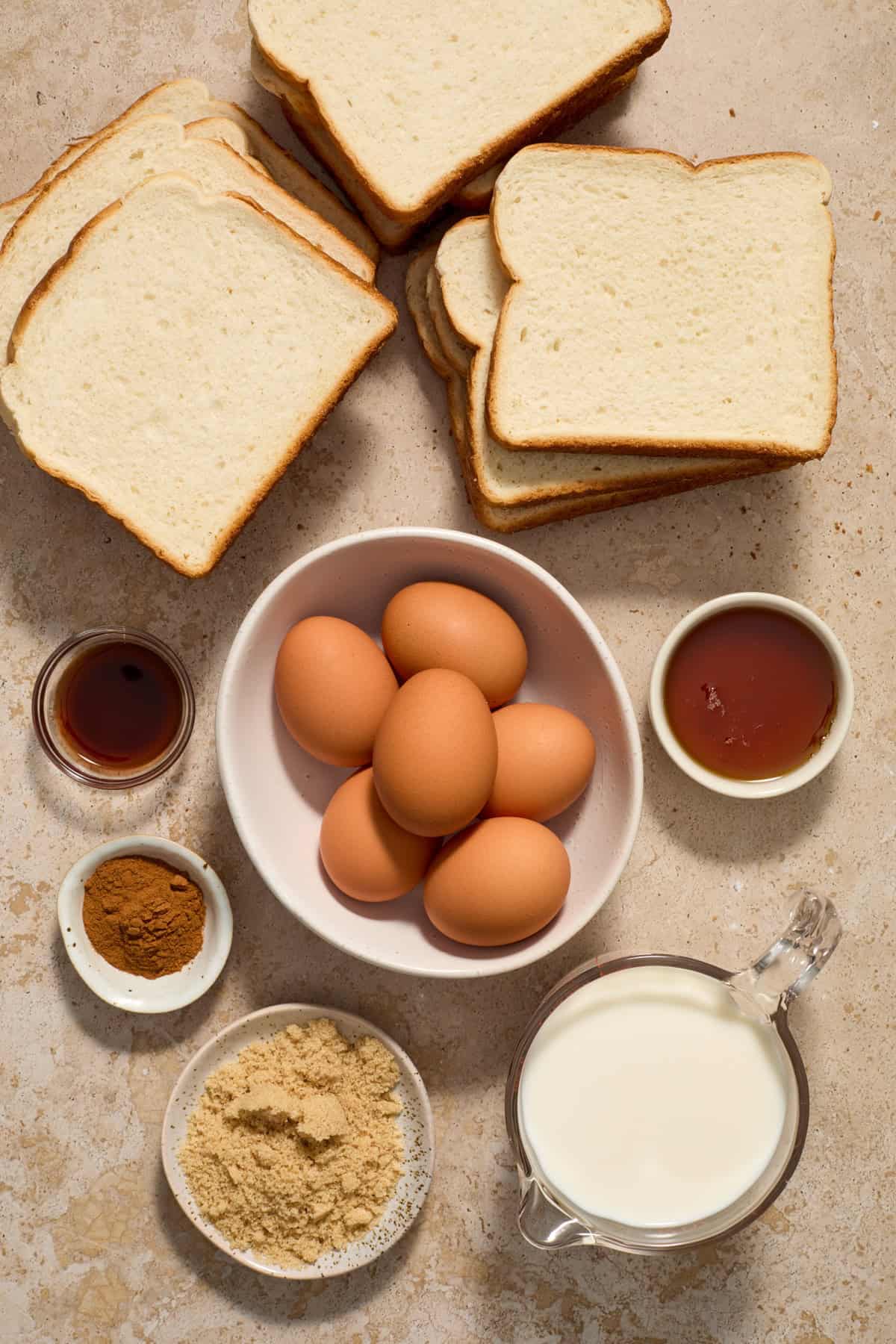 Ingredients needed to make French toast casserole arranged on surface.