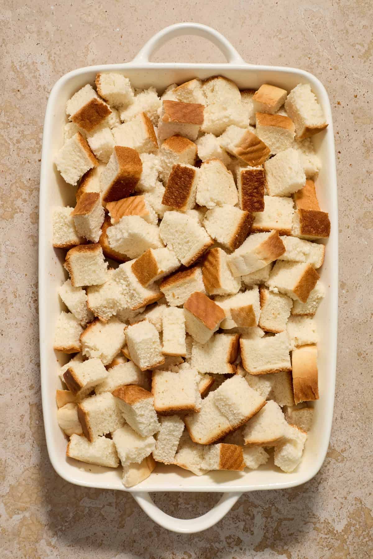 Bread cubes in casserole dish.`