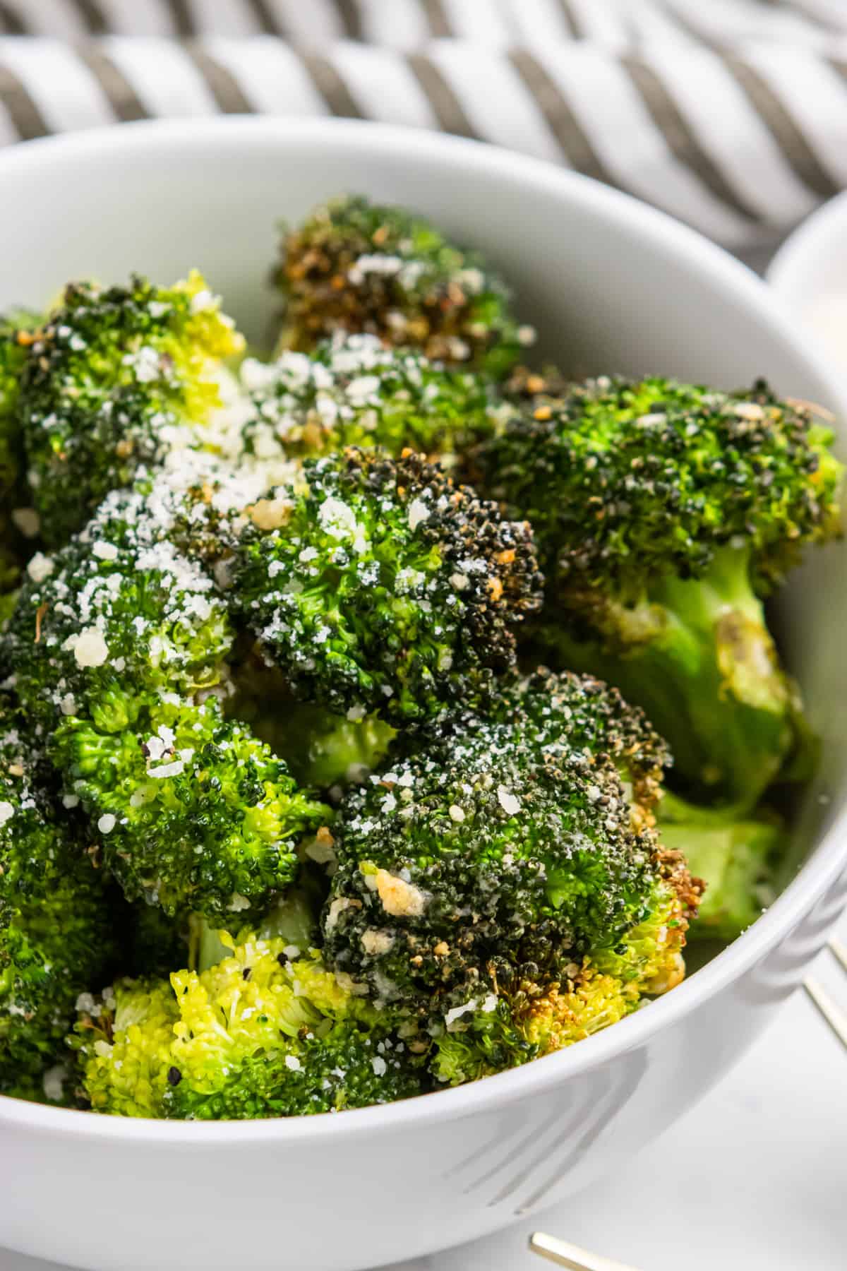 Air fryer broccoli in white bowl with parmesan.