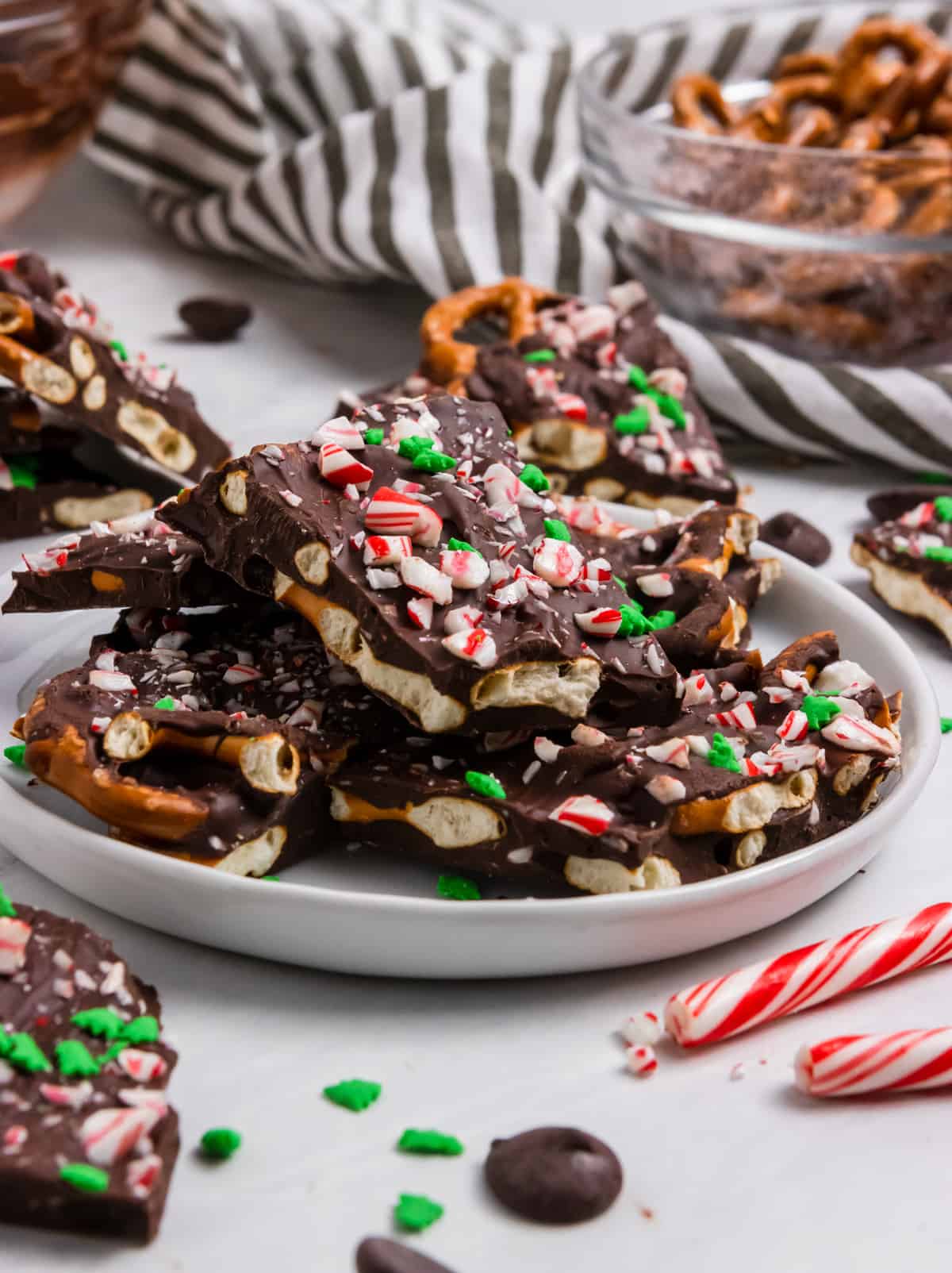 Chocolate Pretzel bark with candy canes and sprinkles on plate.