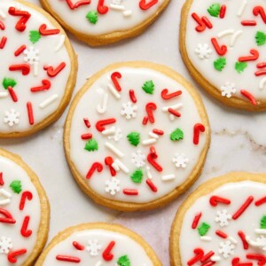 Iced shortbread cookies with Christmas sprinkles arranged on counter.