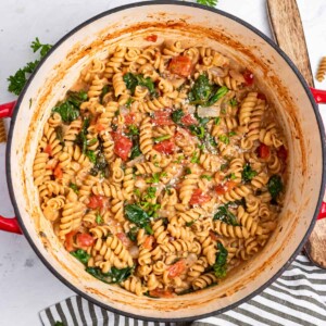 One pot pasta in pan with spinach and parsley.