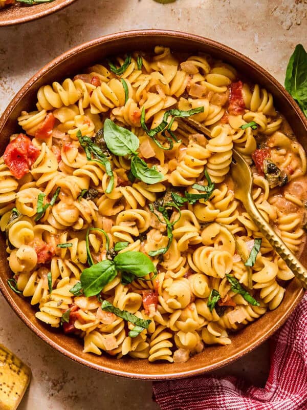 Bowl with creamy one pot pasta topped with fresh basil.