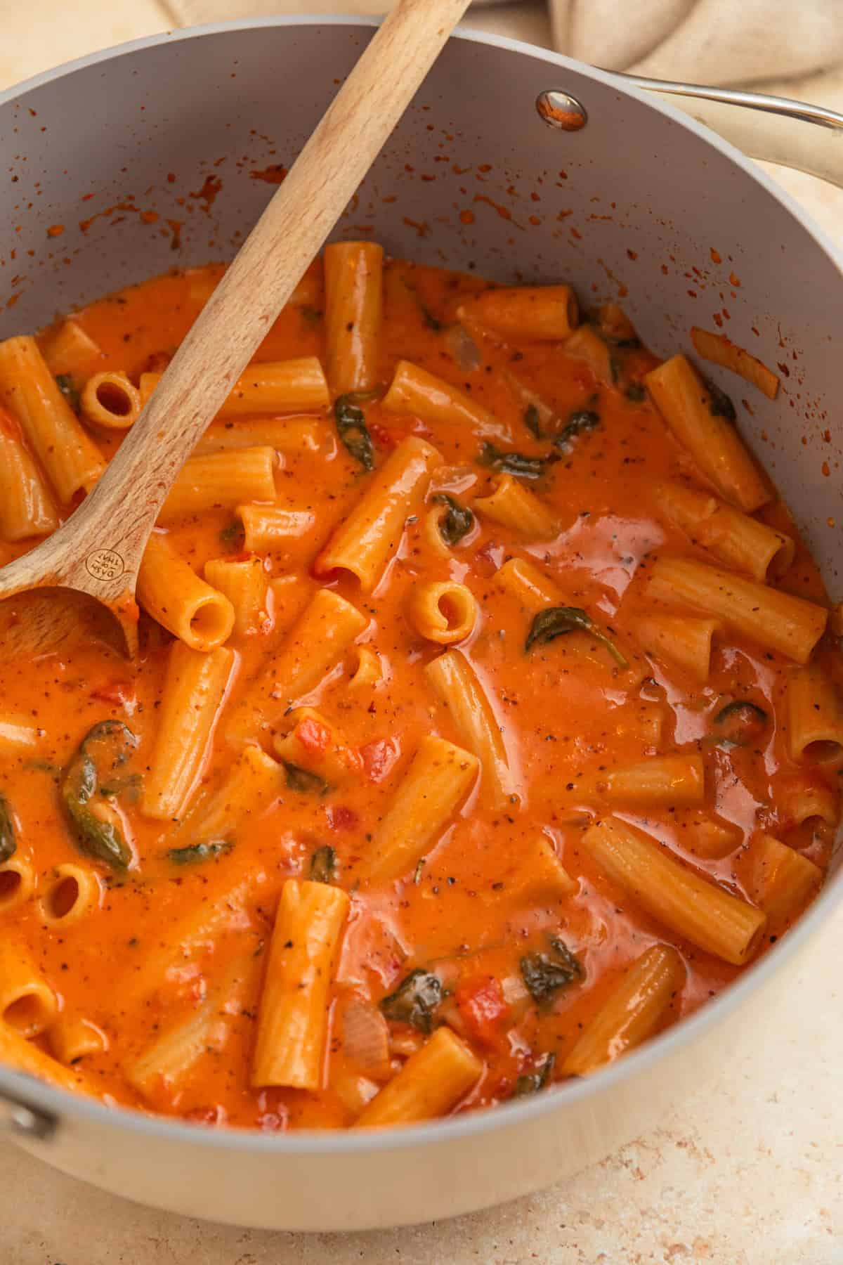 Creamy one pot pasta in pot with wooden spoon.