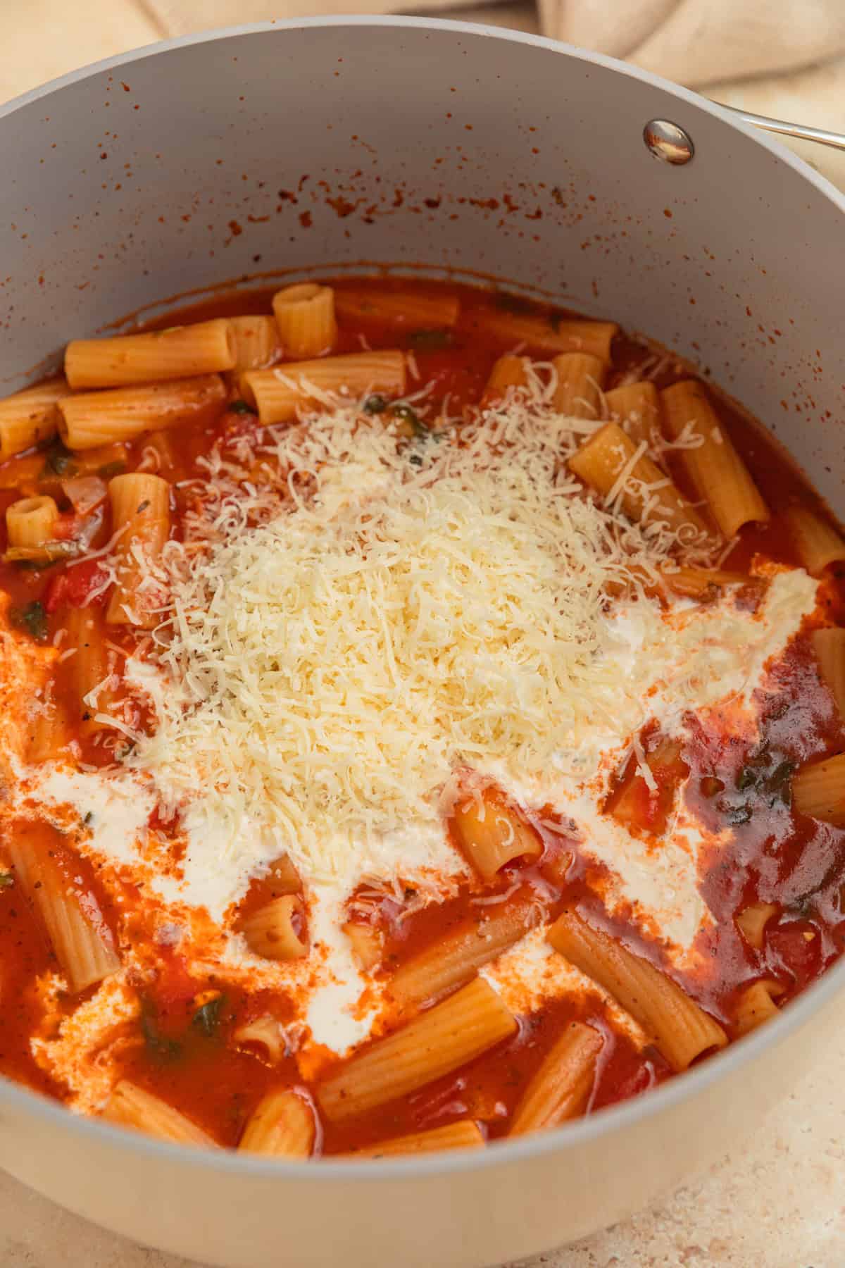 Cream and parmesan added to pot with pasta.