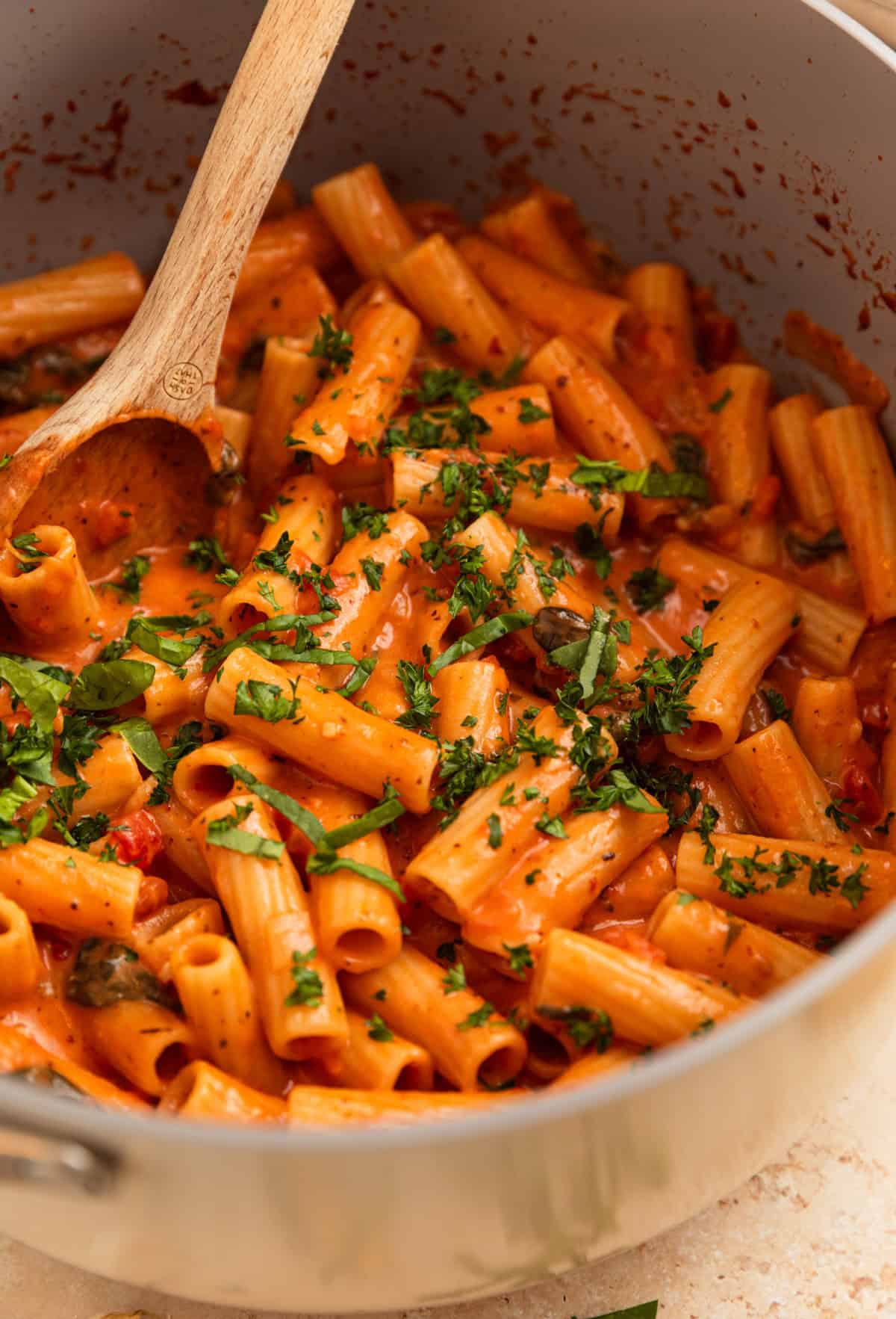 One pot creamy pasta in pot with wooden spoon.