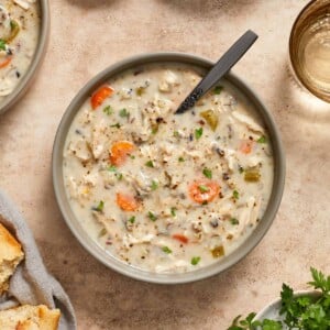 Overhead view of creamy chicken wild rice soup in bowl topped with chopped parsley.