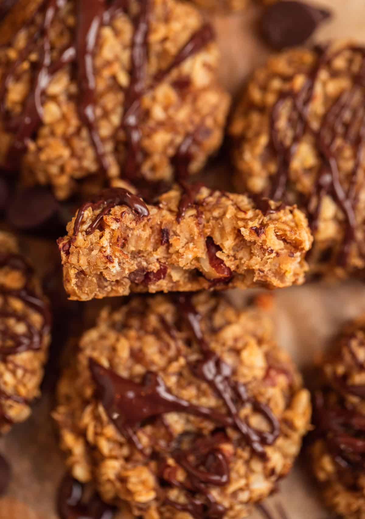 Bite taken out of peanut butter banana oatmeal cookie with chocolate drizzle over top.