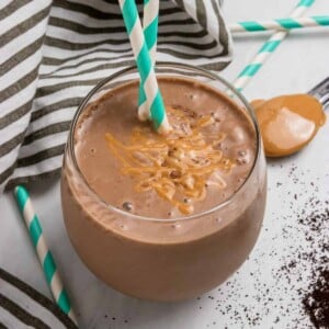 Peanut butter coffee smoothie in cup with straw.
