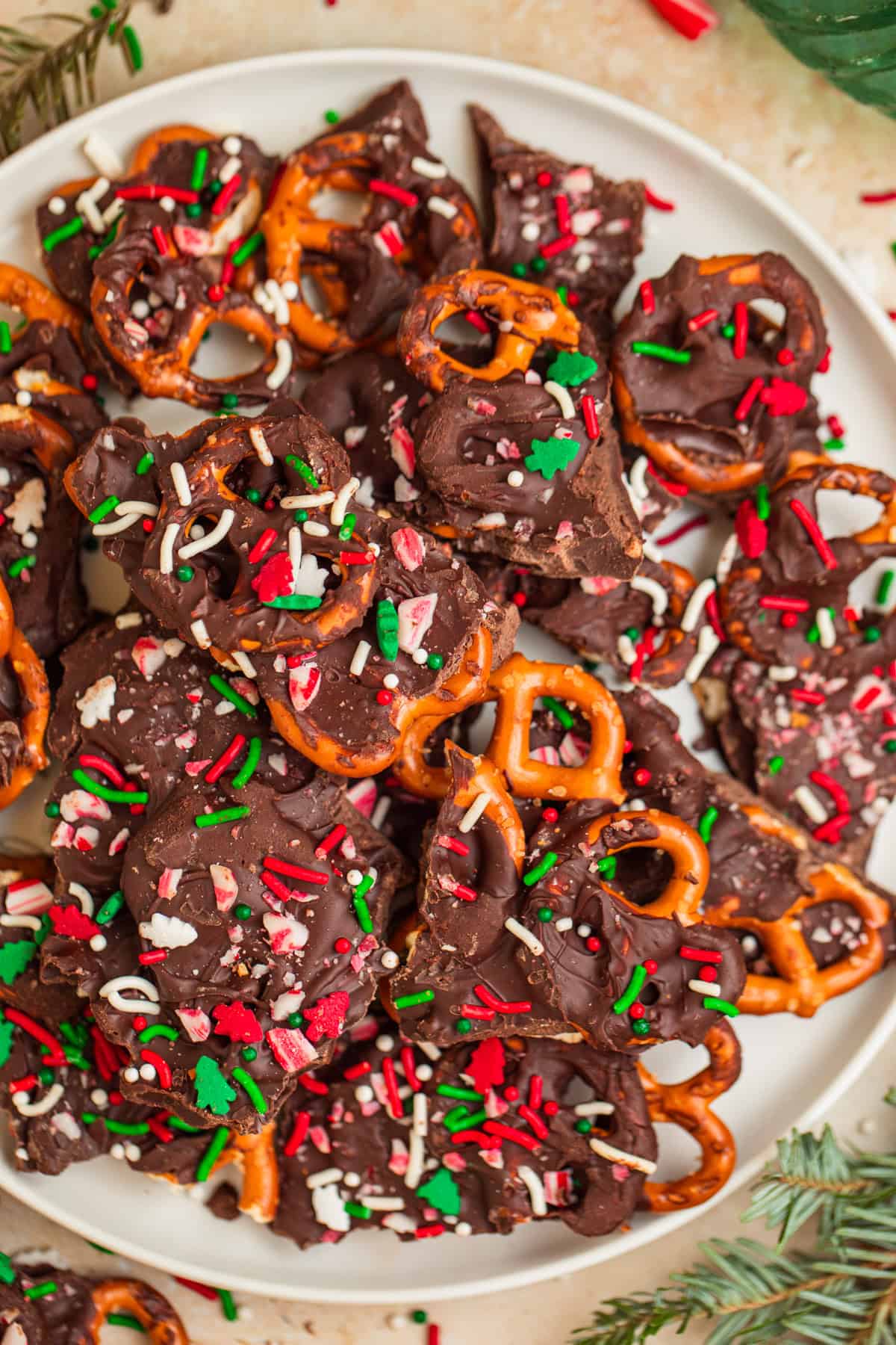 Plate with pretzel and chocolate mint bark topped with red and green sprinkles.