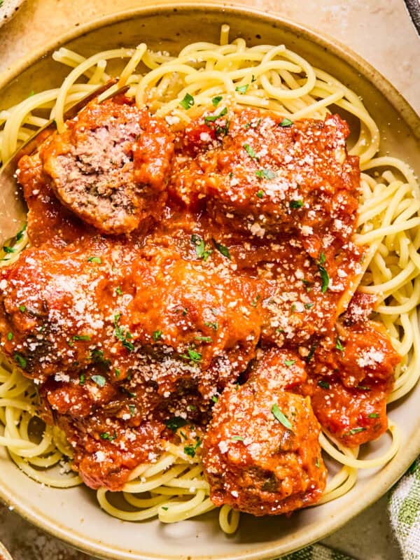 Plate with spaghetti and meatballs topped with fresh parmesan.
