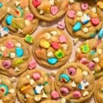 Lucky charm and white chocolate chip cookies on surface.