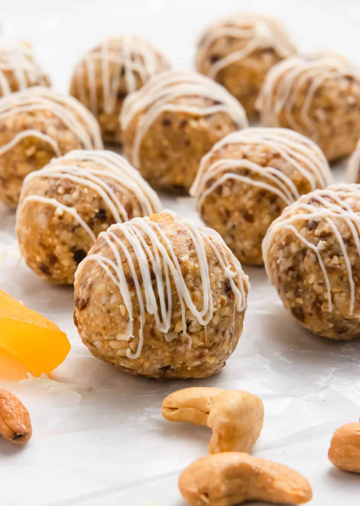 Mango bites on parchment with cashews and drizzle.