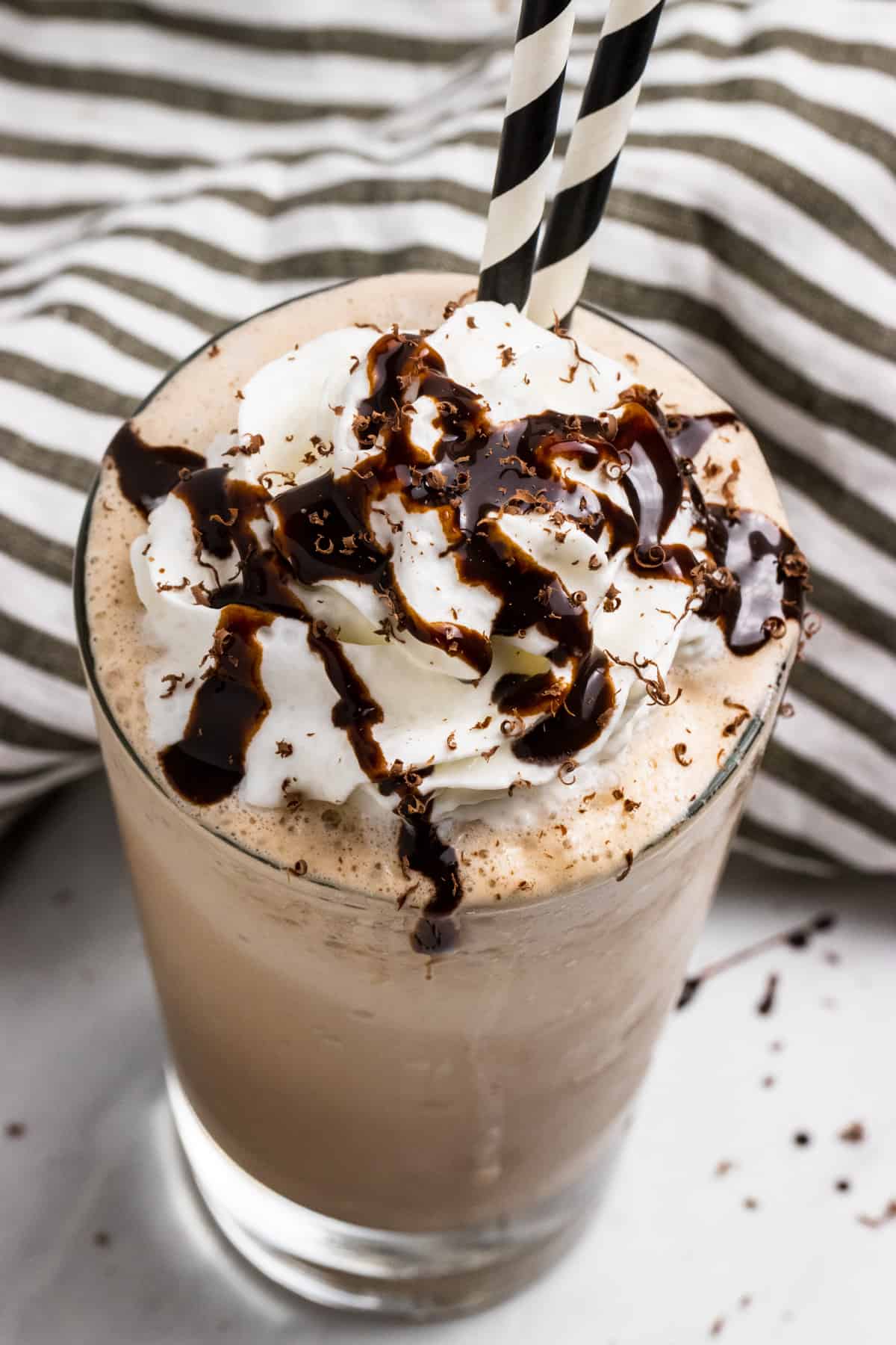 Homemade mocha frappuccino in glass with whipped cream.