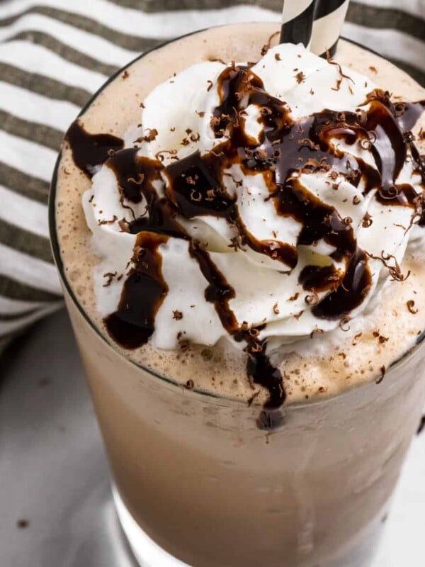 Mocha Frappuccino in glass with whipped cream and chocolate drizzle.