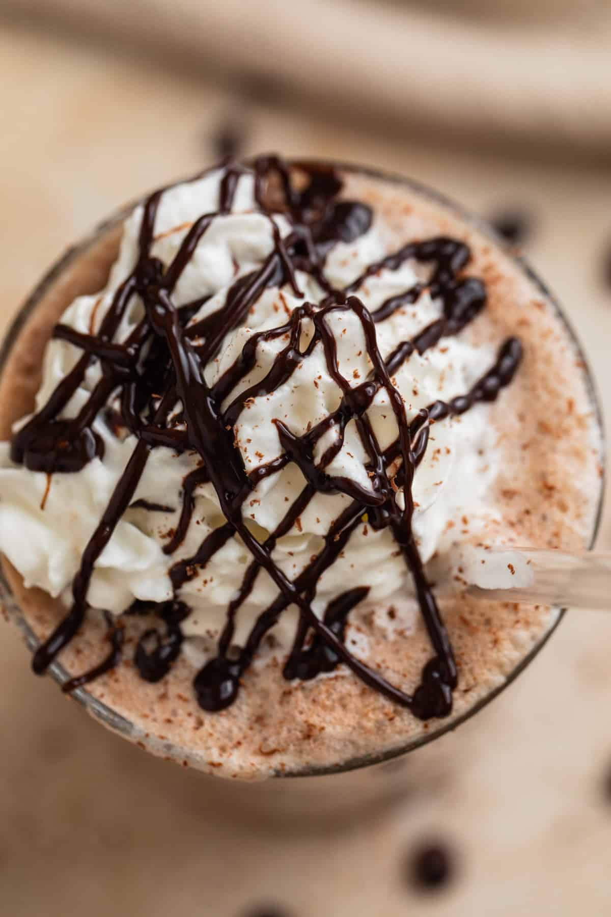 Homemade frappuccino in glass topped with chocolate drizzle.