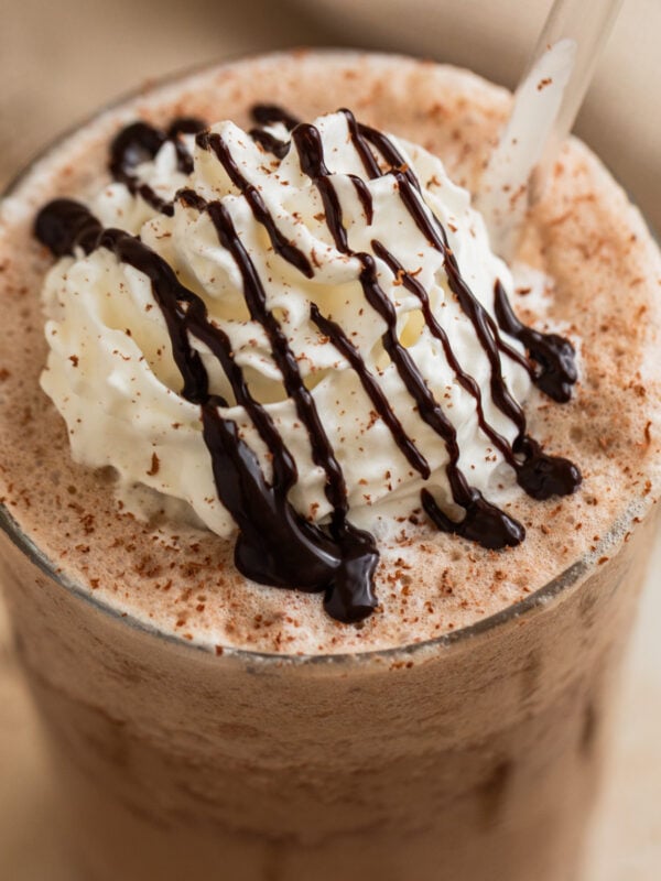 Mocha frappuccino iced coffee drink in glass with whipped cream and chocolate shavings.