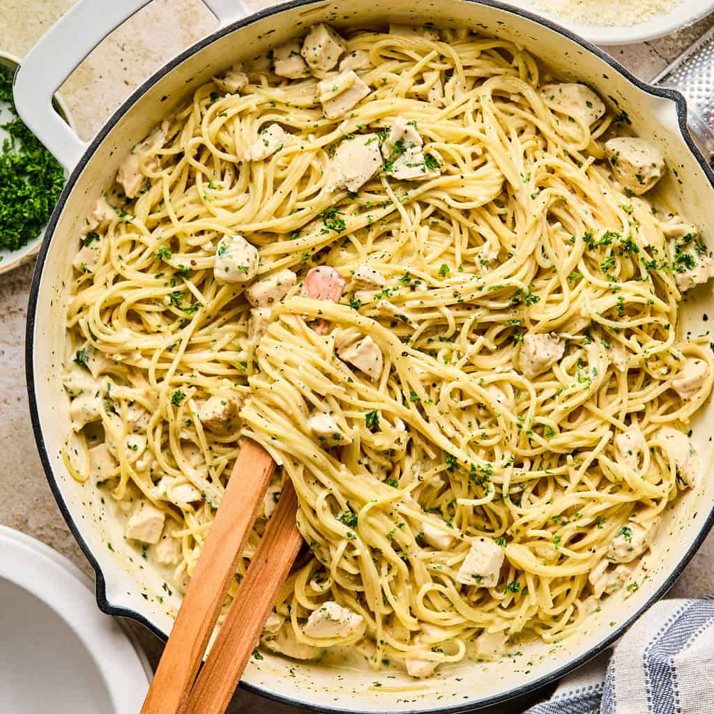 Pot with chicken Alfredo topped with parsley.