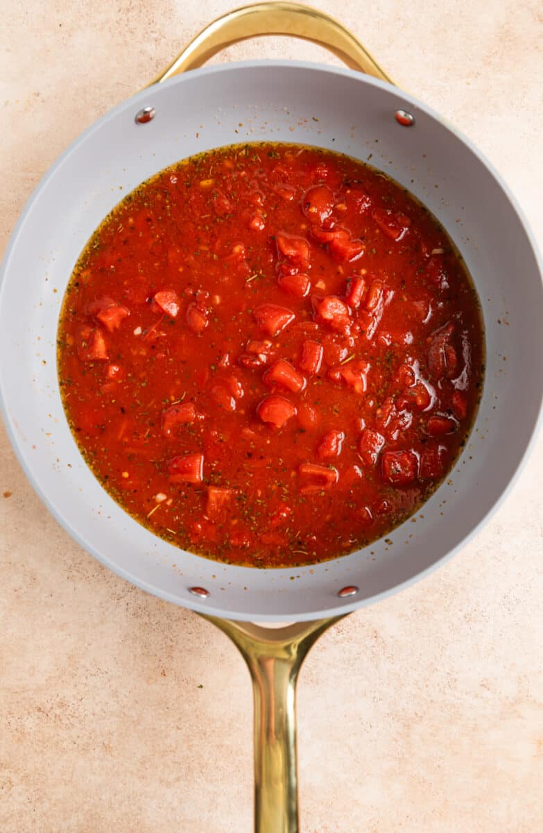Tomatoes, broth, garlic and seasoning in skillet.