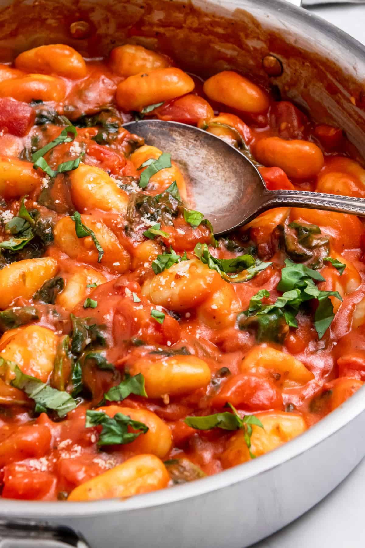 Pot with gnocchi cooked in tomatoes with basil.