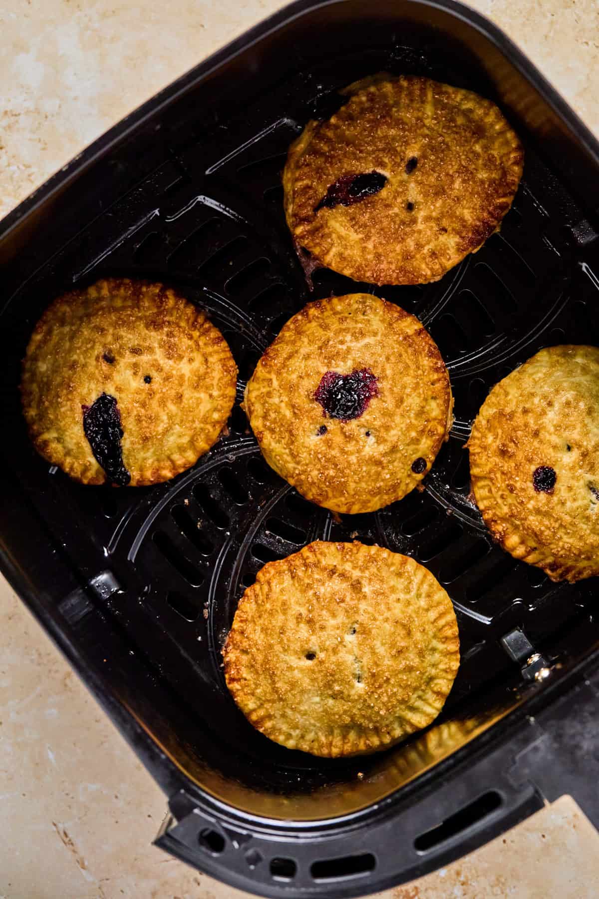 Cooked Air Fryer mini pies in air fryer basket.