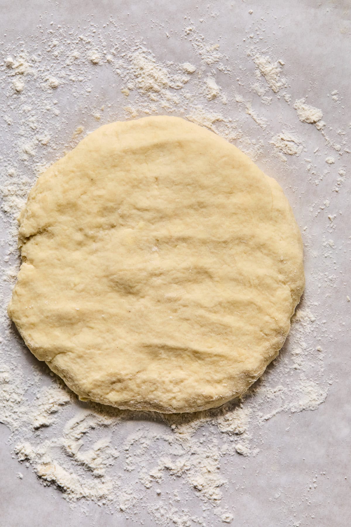 Disc of pie crust rolled out on floured surface.