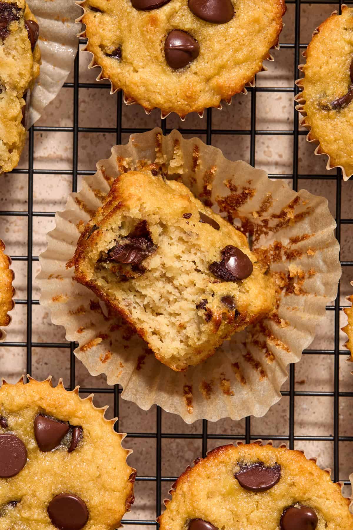 Overhead view of almond flour banana bread muffins with bite taken out of one muffin to show texture.