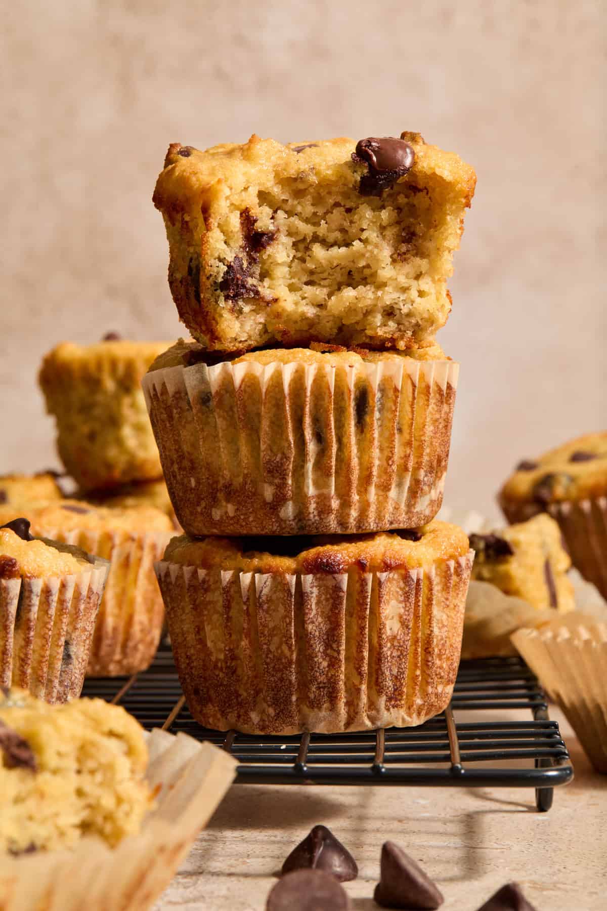 Stack of almond flour banana bread muffins with chocolate chips with bite taken out of top muffin.