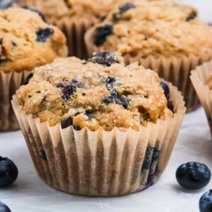 Banana blueberry muffin on counter with blueberries.