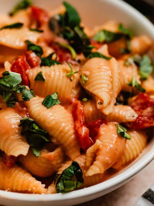 Creamy pasta with tomatoes and spinach topped with chopped fresh basil.