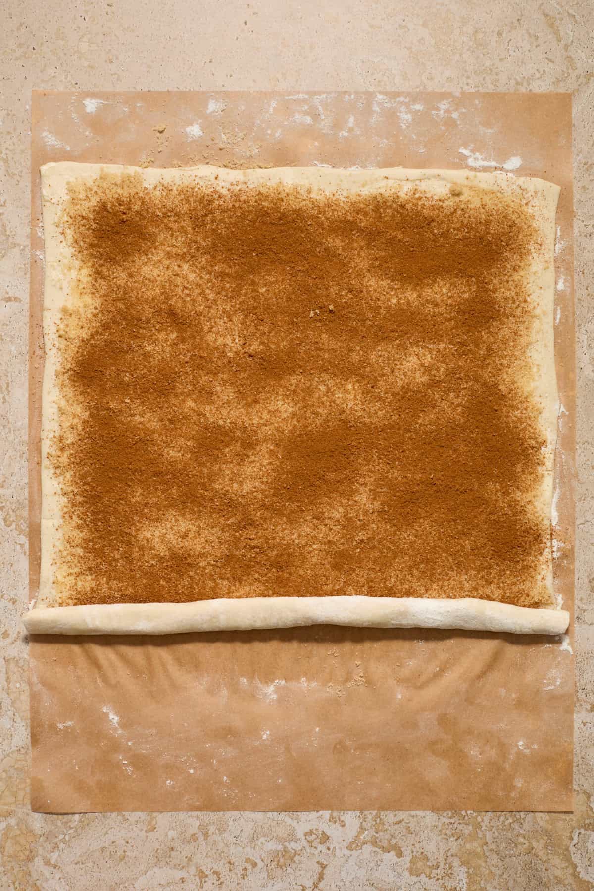 Cinnamon roll with the start of rolling up.