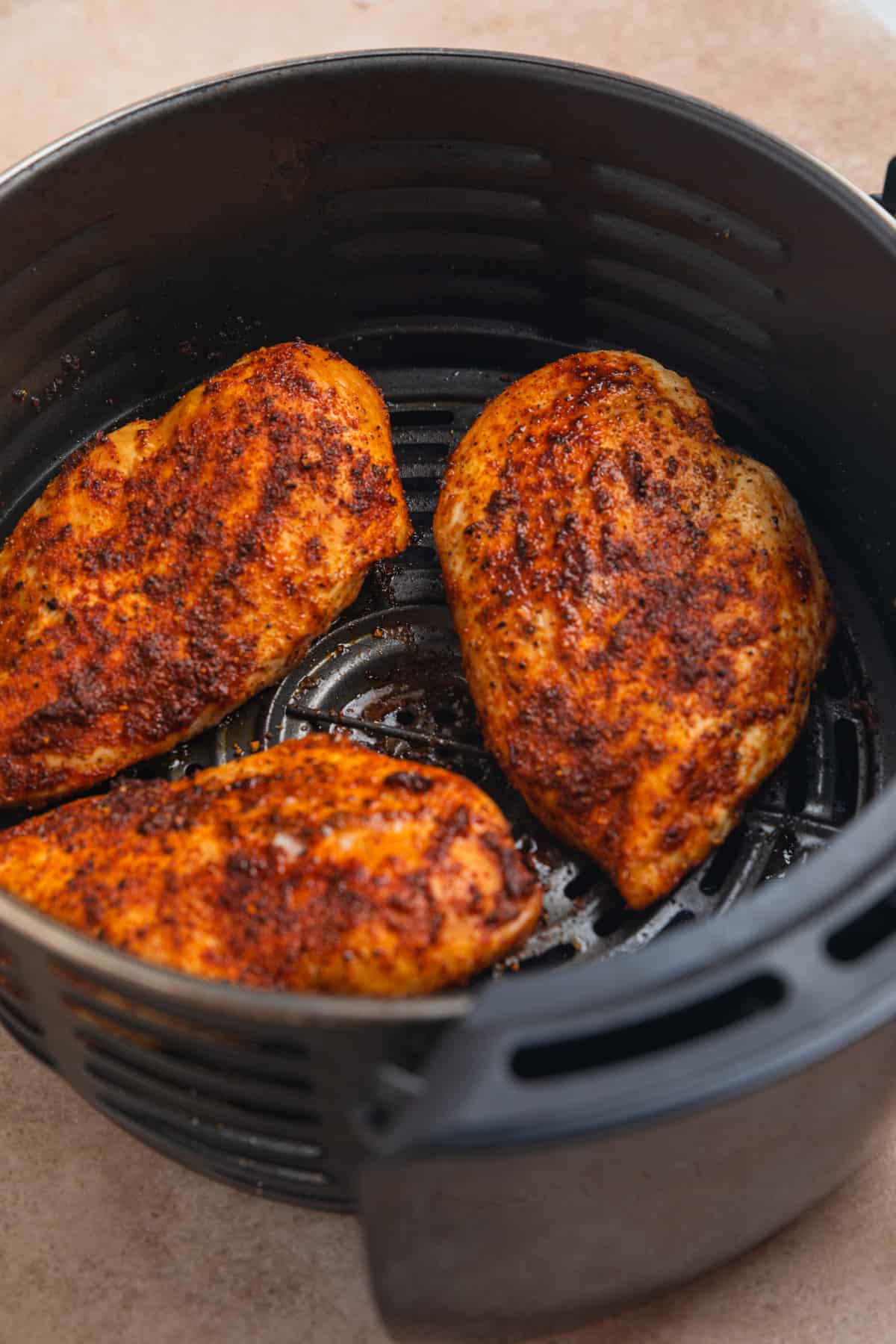 Chicken breast in air fryer after flipping.