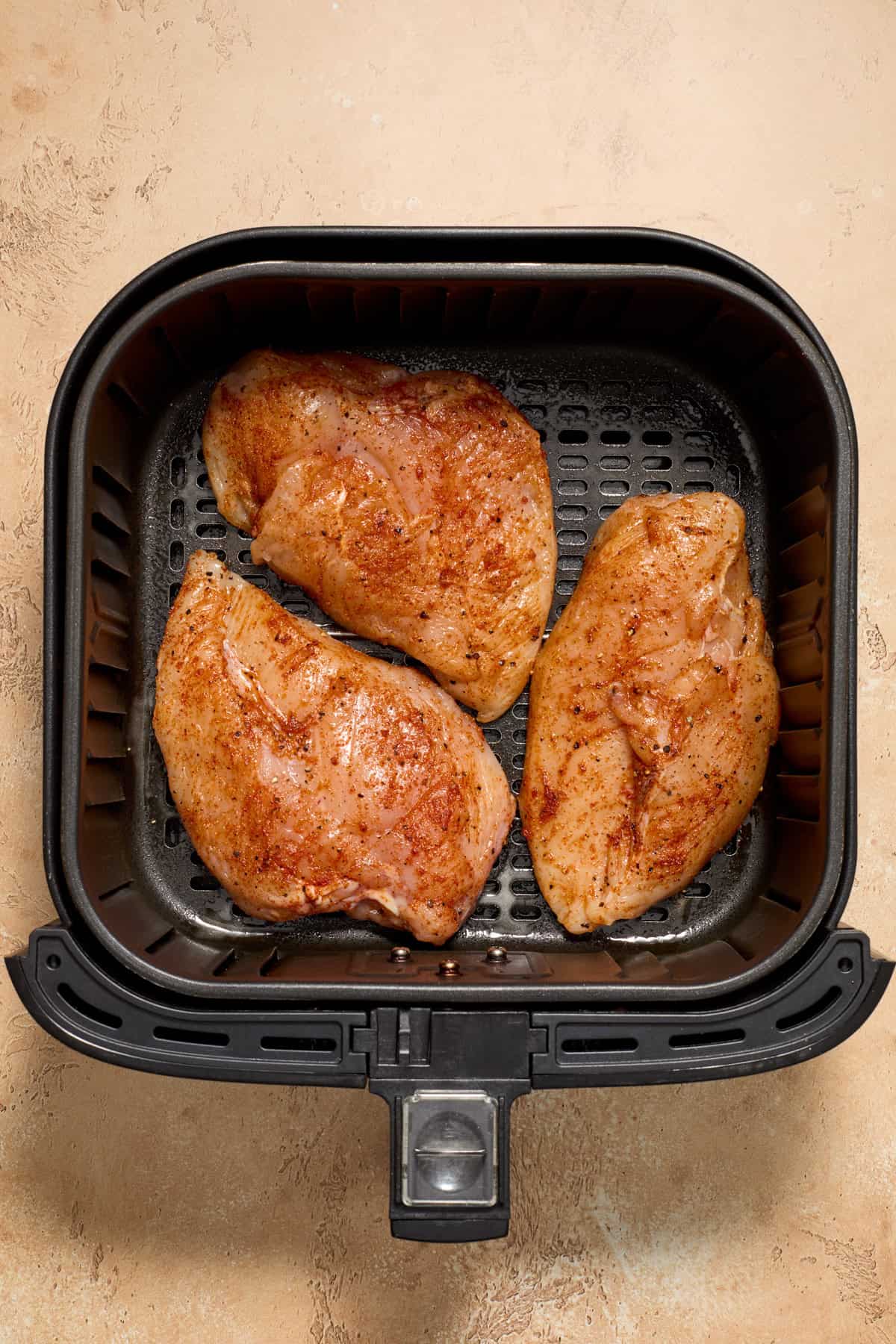 Chicken in air fryer before being cooked.