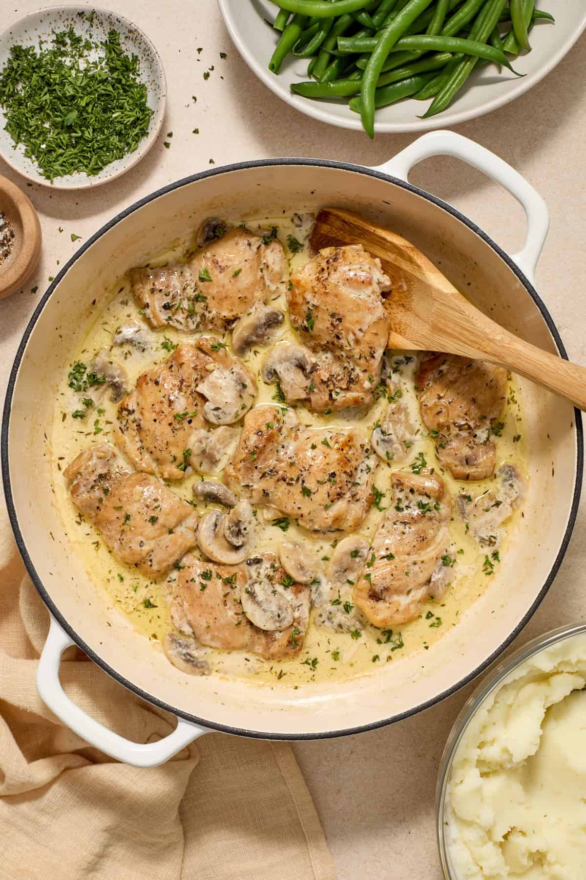 Overhead view of chicken and mushrooms in skillet.