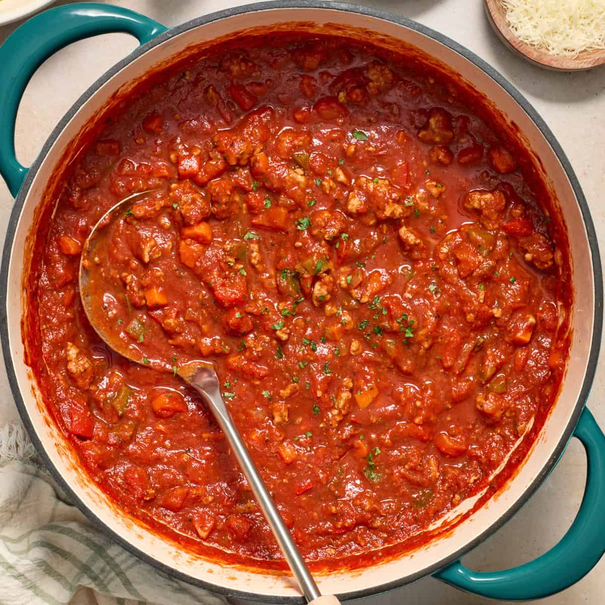 Ground turkey spaghetti sauce in pot with ladle.
