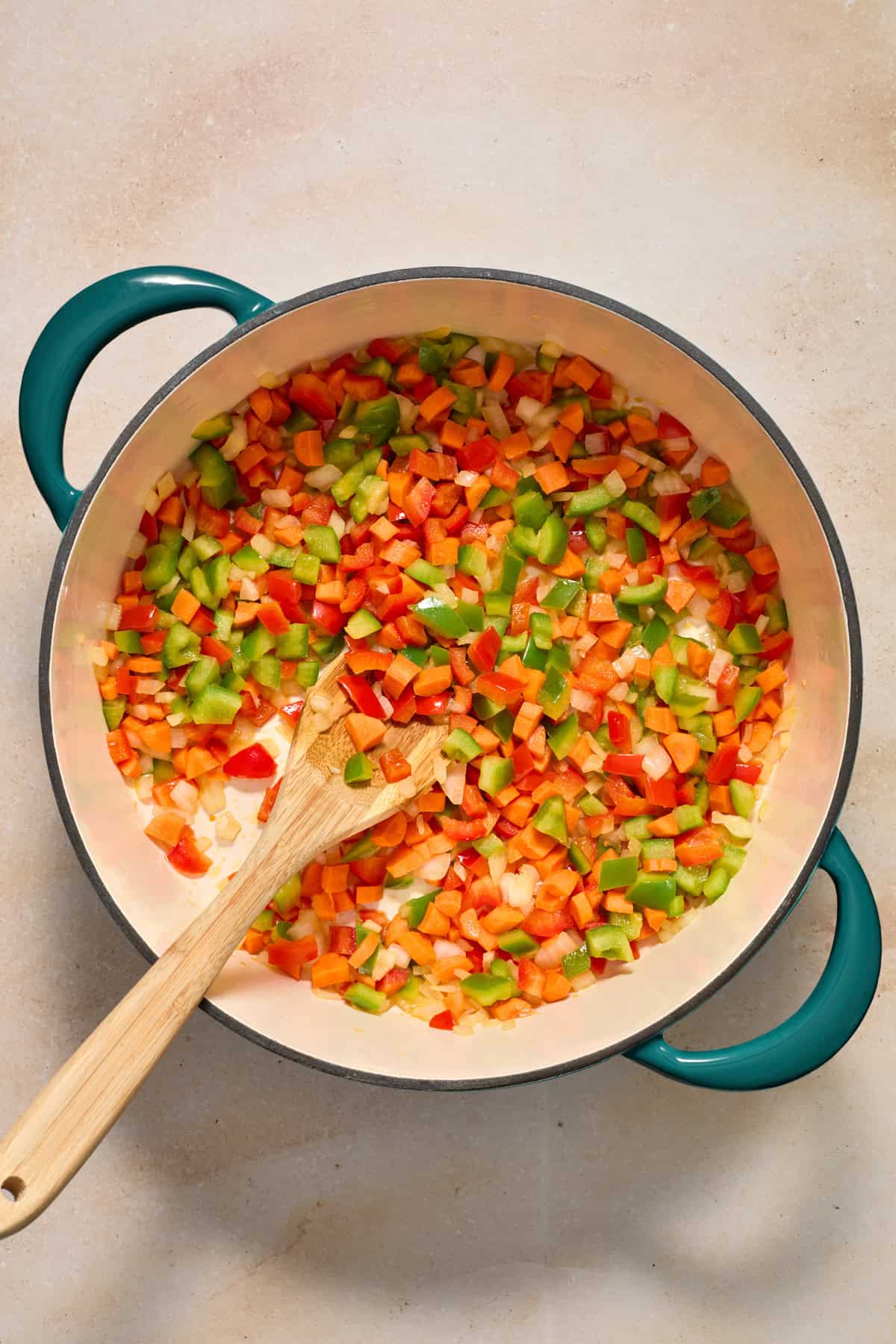 Onions, carrots, and peppers in dutch oven.