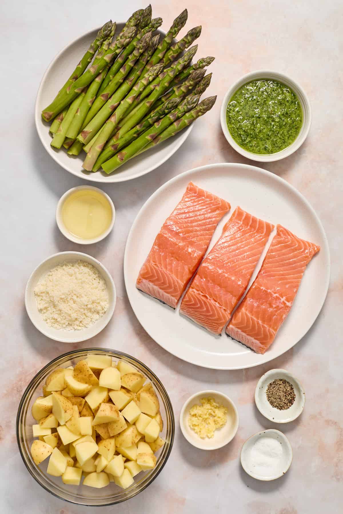 Salmon, asparagus, parmesan, potatoes and other ingredients on counter.