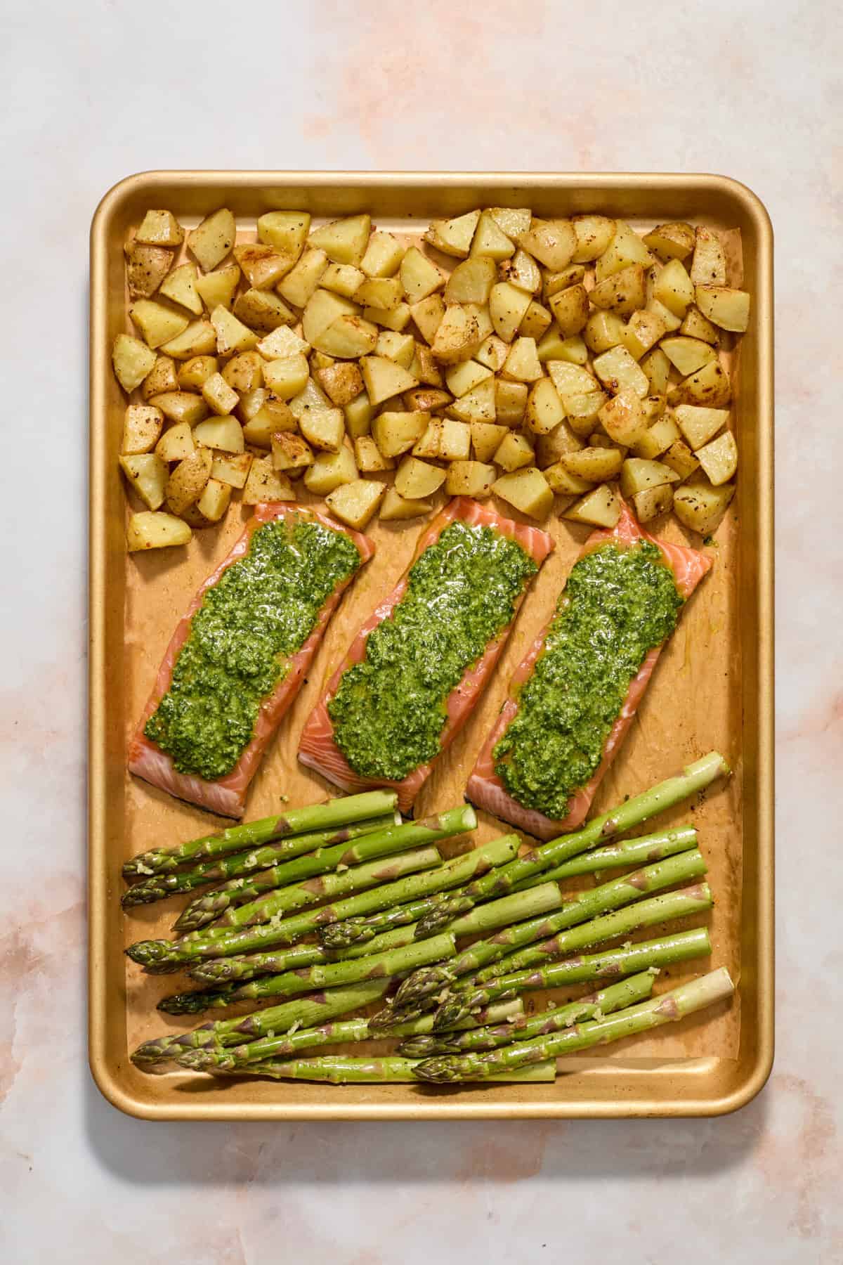 Asparagus added to pan with pesto salmon and roasted potatoes.