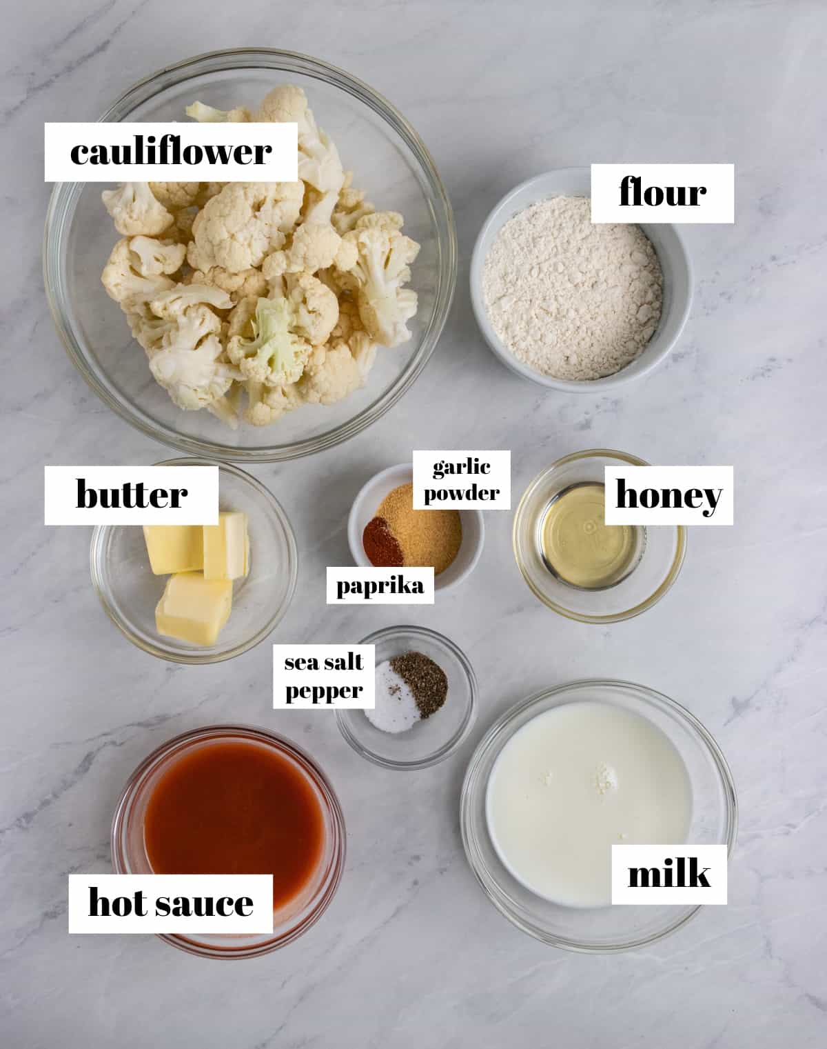 Hot sauce, butter, milk, flour and other ingredients labeled on counter.