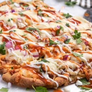 BBQ chicken flatbread with ranch and bbq sauce drizzle and fresh cilantro.