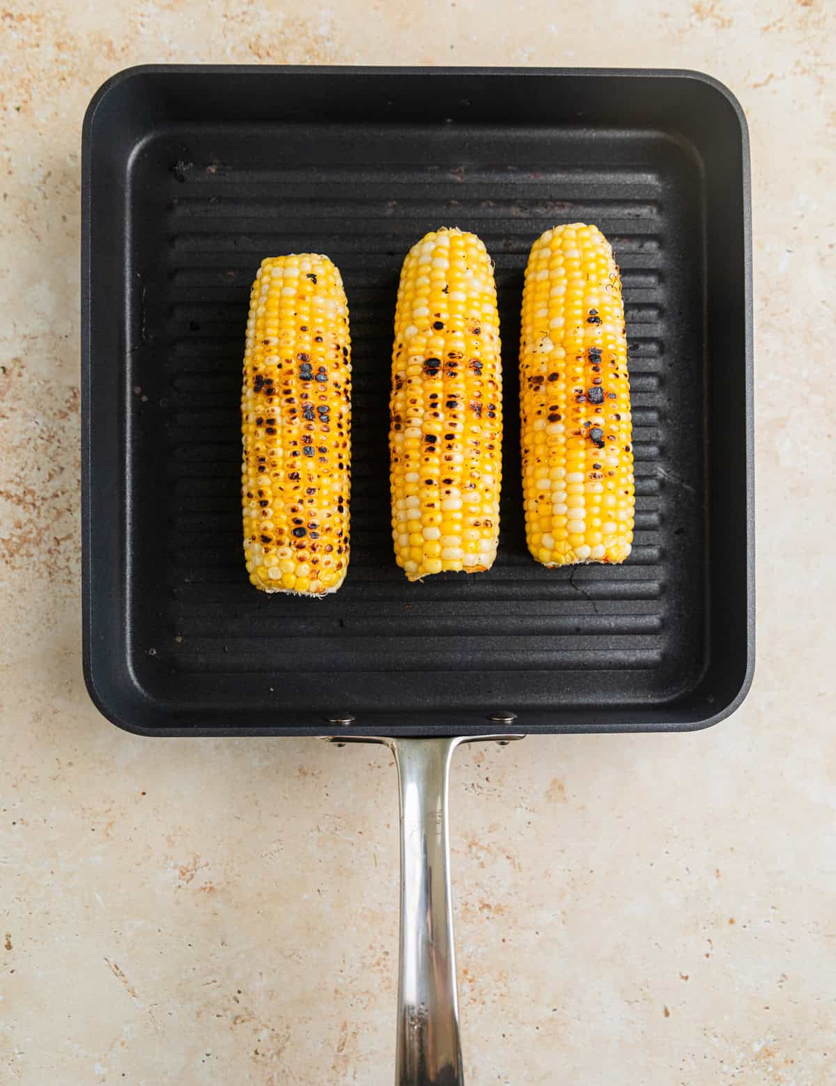 Grilled corn on grill pan.