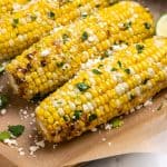 Cilantro lime air fryer corn on the cob sitting on brown parchment.