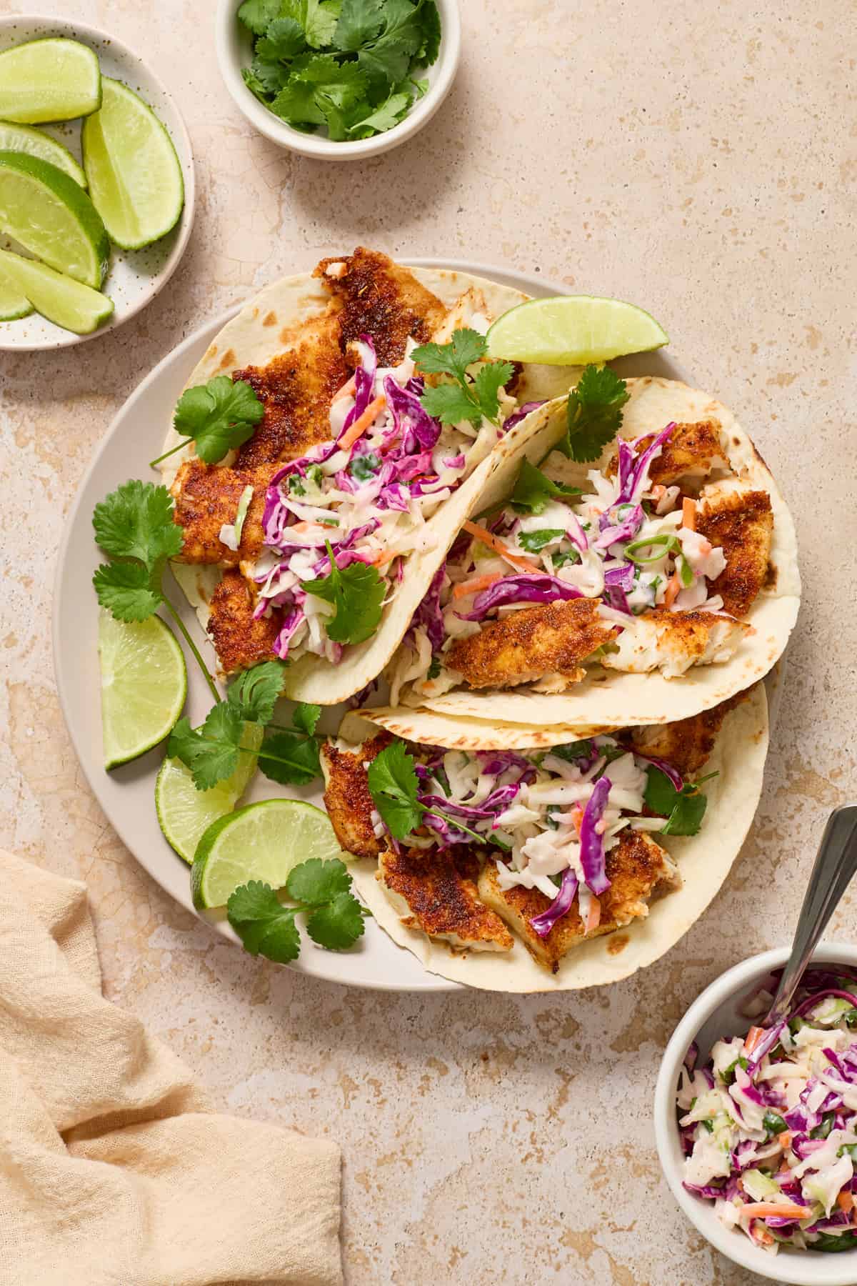 Air fryer fish tacos on white plate with lime.