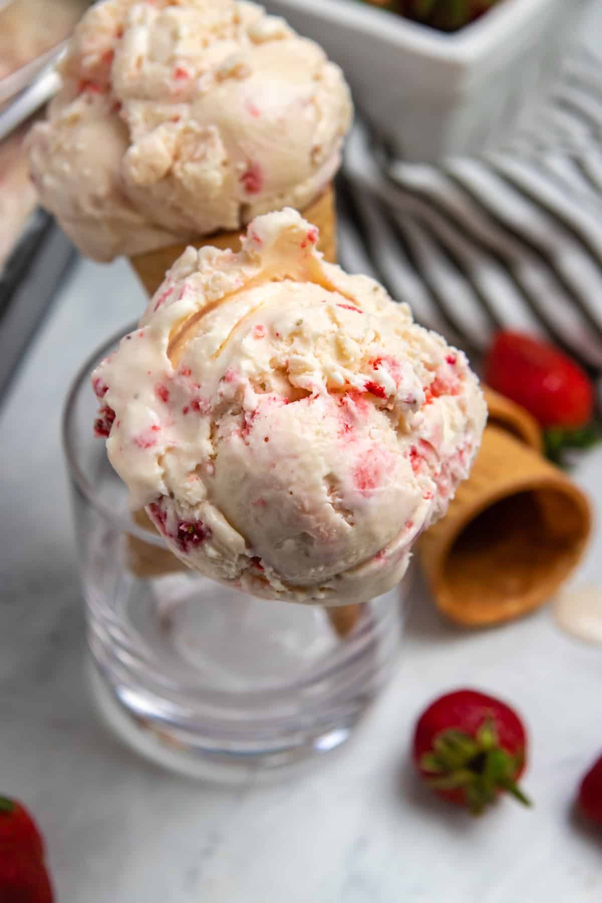 Ice cream cones held up in glass cup.