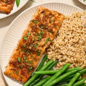 Maple citrus glazed salmon on plate with rice and vegetables.